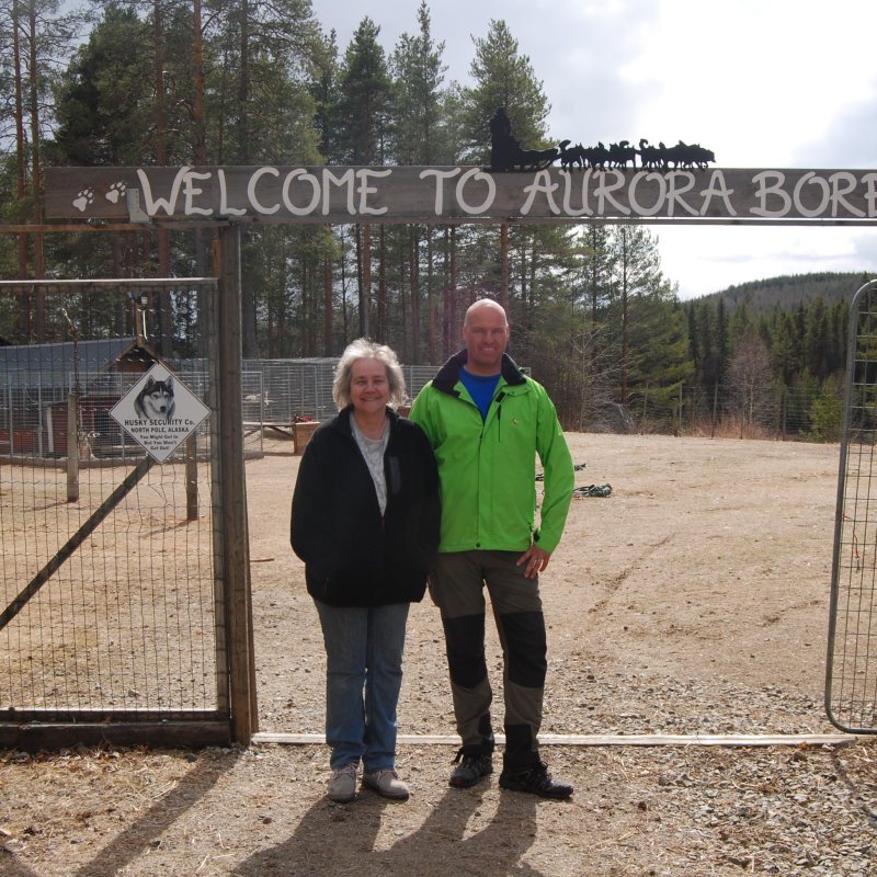 a man and a woman standing in front of a fence